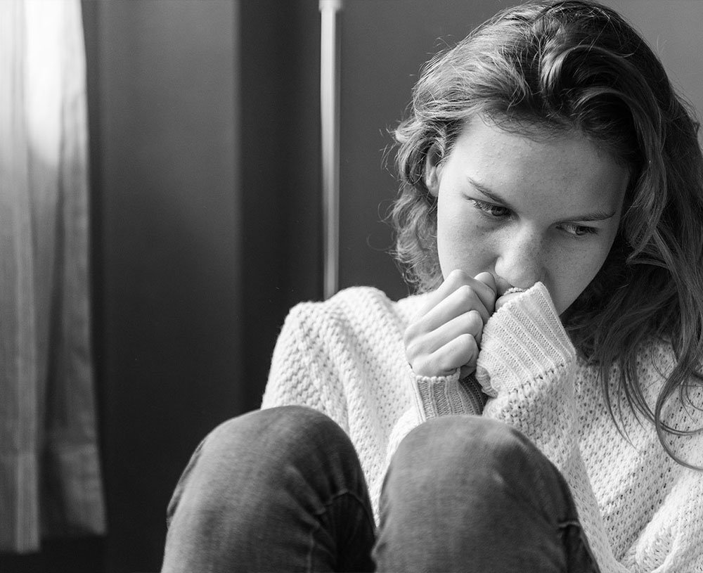 Woman feeling anxious and overwhelmed, sitting quietly